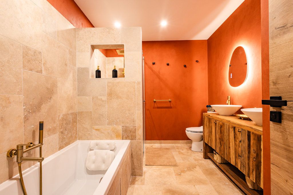 A modern bathroom with a freestanding bathtub, a wooden vanity, and a large mirror.