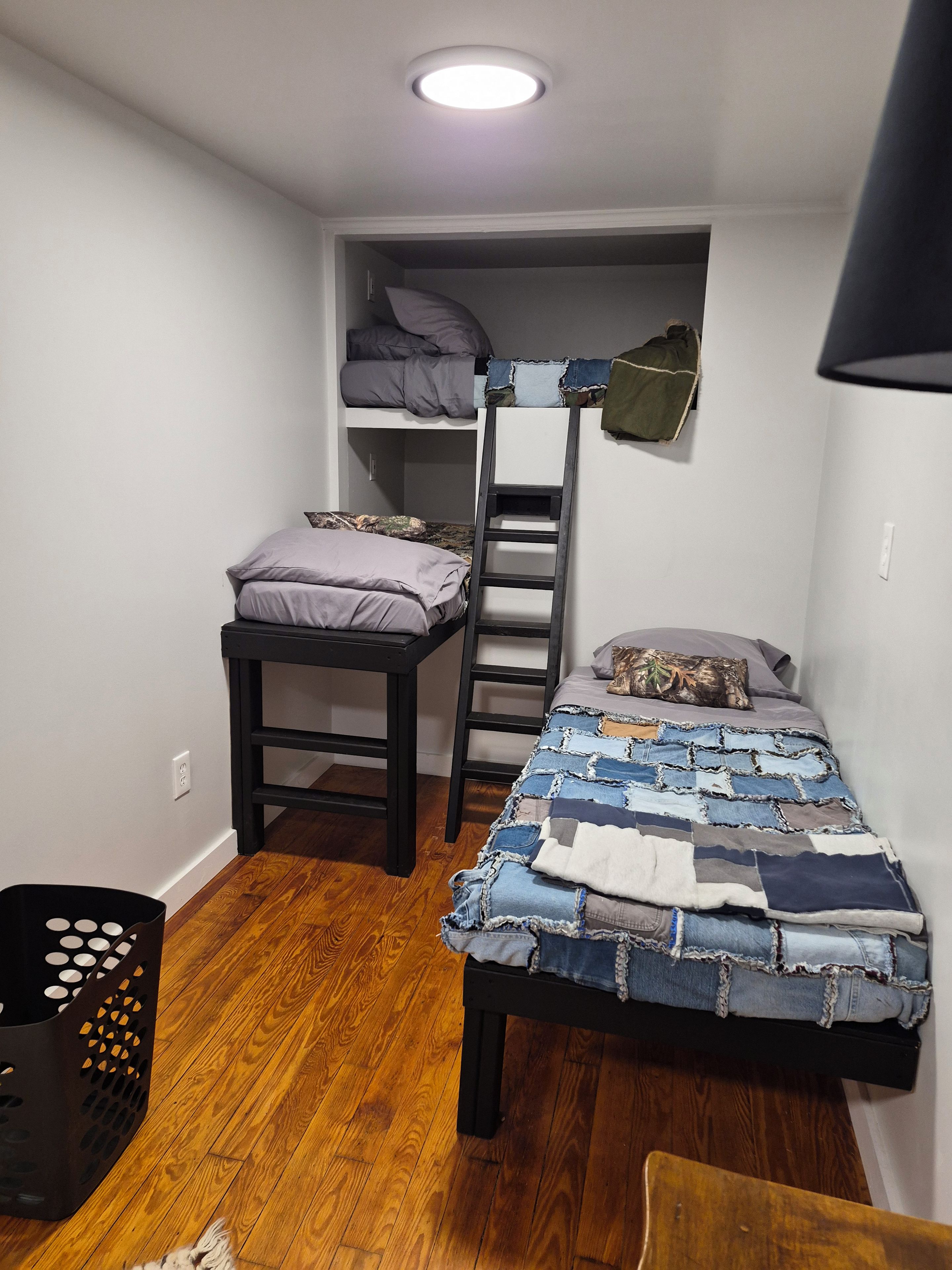 Una habitación pequeña con literas, un escritorio y una silla.