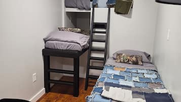 Una habitación pequeña con literas, un escritorio y una silla.