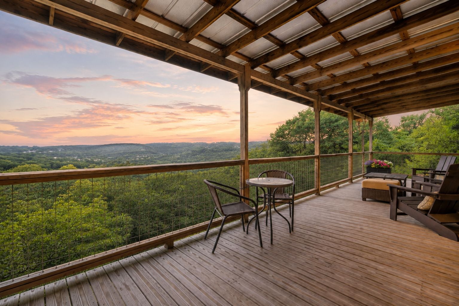 Une terrasse en bois avec une table et des chaises, donnant sur un paysage boisé.