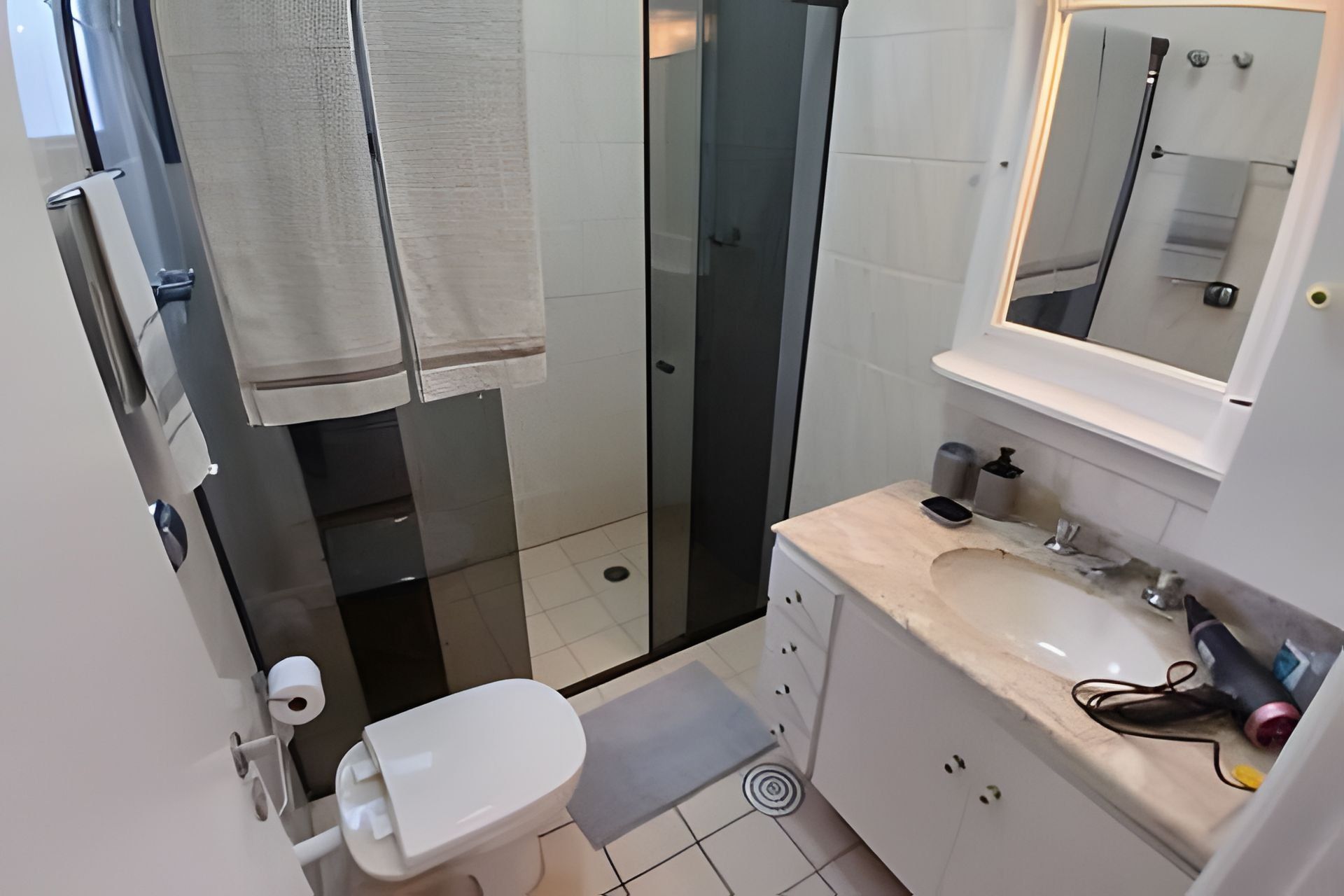 A bathroom with a toilet, a sink, and a shower.