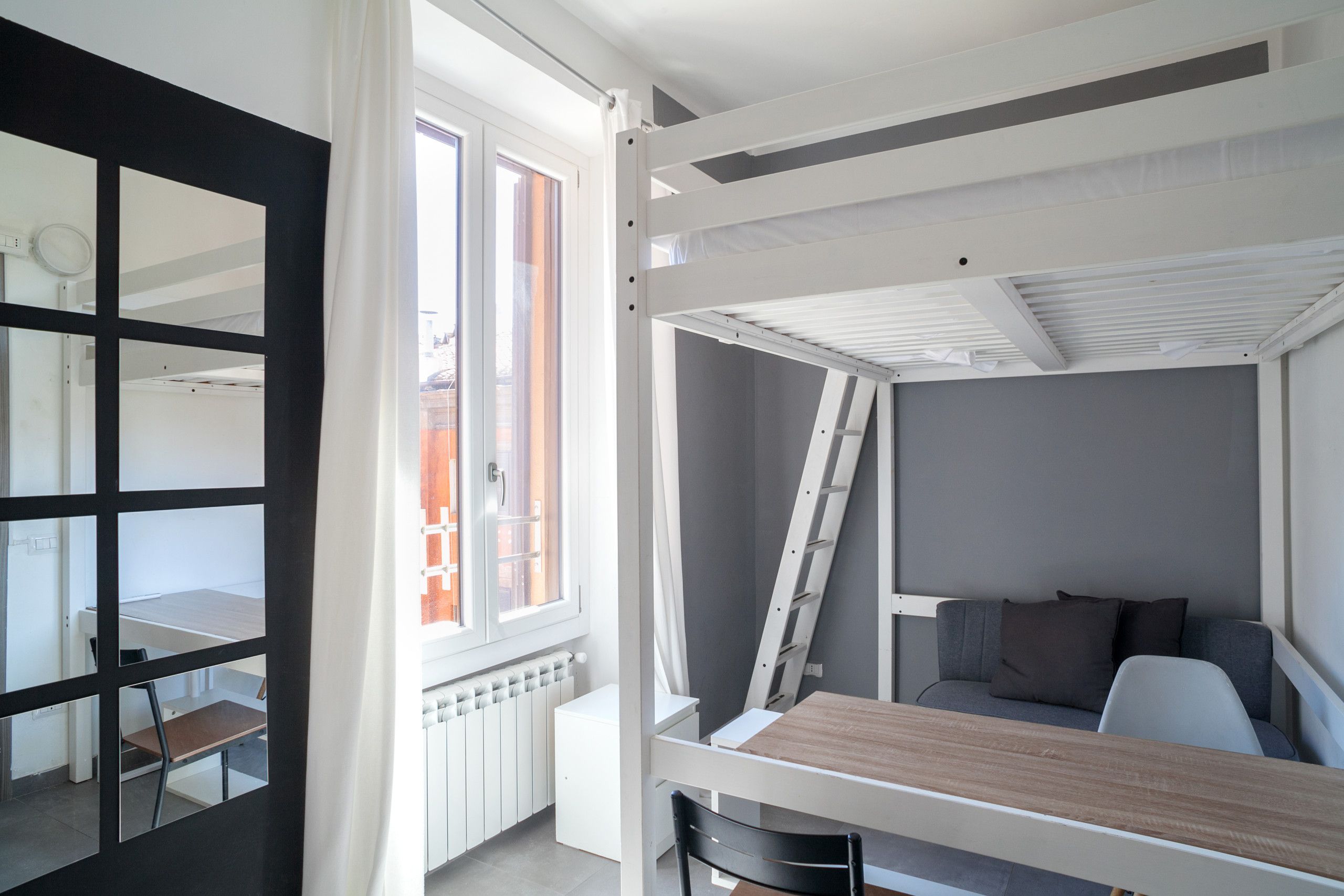 Habitació petita amb literes, escriptori i cadira.
