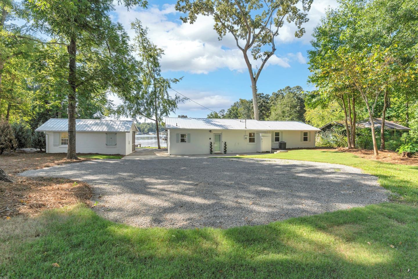 A two-story building with a gravel driveway leading to a covered entrance.