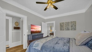 A bedroom with a bed, a ceiling fan, a television, a dresser, and artwork on the walls. - The Eddie At Mount Carmel- Peaceful, Sleeps 4 (Monroe)