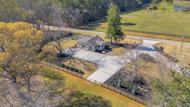 A residential property with a large driveway, a detached garage, and a fenced yard. - The Eddie At Mount Carmel- Peaceful, Sleeps 4 (Monroe)