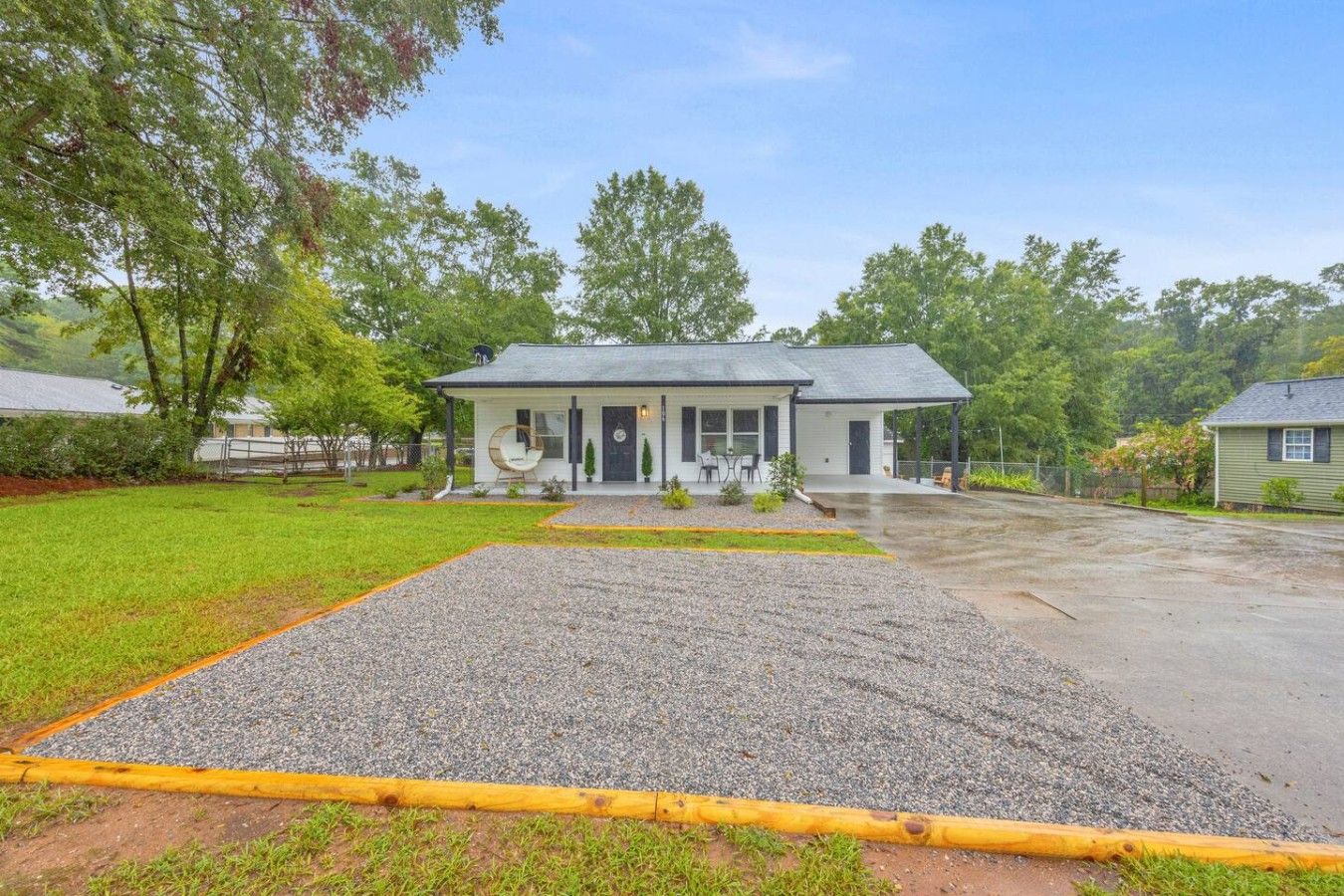 A single-story house with a covered porch, a gravel driveway, and a well-maintained lawn.