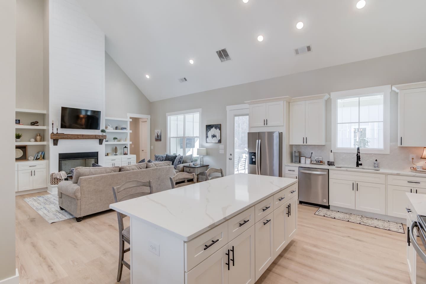A modern kitchen with a large island, built-in appliances, and a dining area with a sofa.