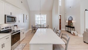 A spacious kitchen with a central island, white cabinetry, and a modern microwave. - The Retreat at Mount Carmel-Peaceful Sleeps 6 (Monroe)