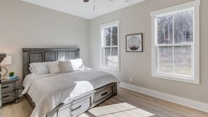 A bedroom with a bed, nightstands, a ceiling fan, and large windows. - The Retreat at Mount Carmel-Peaceful Sleeps 6 (Monroe)