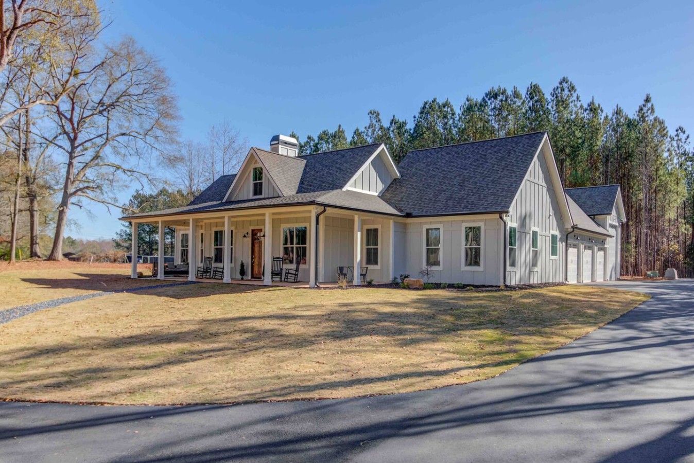 A two-story house with a covered porch, a garage, and a driveway.
