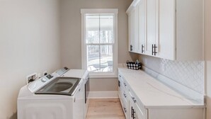 A laundry area with a washing machine, dryer, and a window providing natural light. - The Retreat at Mount Carmel-Peaceful Sleeps 6 (Monroe)