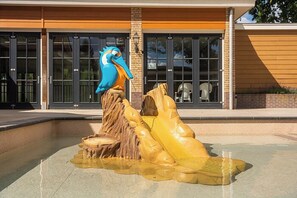 A sculpture of a bird perched on a rock formation in front of a building with large windows. - 8P Veluwe Wellness Villa | Sauna, Hot Tub & BBQ (Voorthuizen)