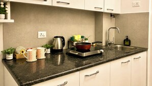 Una cucina con piano di lavoro in granito, elettrodomestici in acciaio inossidabile e mobili bianchi.