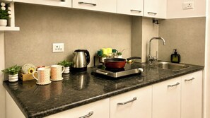 Una cocina con encimera de granito, electrodomésticos de acero inoxidable y armarios blancos.