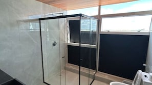 A modern bathroom with a glass shower enclosure, a toilet, and a sink. - Hotel Novo Centro (Petrolina)
