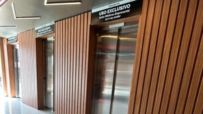 A modern building with vertical wooden paneling and a sign indicating an exclusive use elevator.