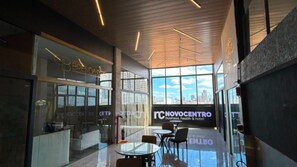 A modern interior with glass partitions, a city view, and a sign for Novocentro. - Hotel Novo Centro (Petrolina)