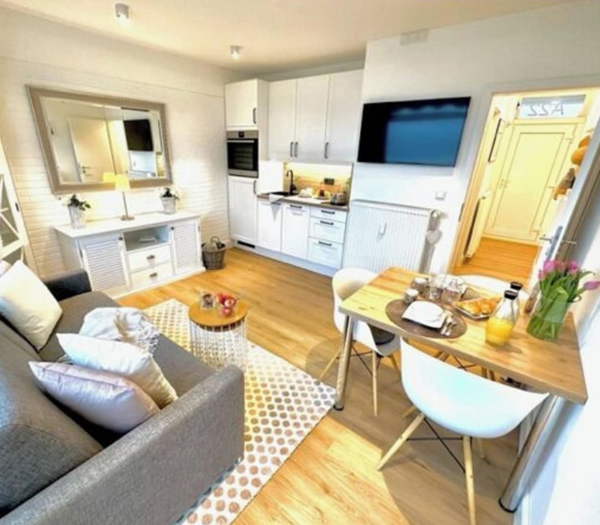A compact living space with a sofa, dining table, and kitchenette.