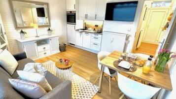 A compact living space with a sofa, dining table, and kitchenette.