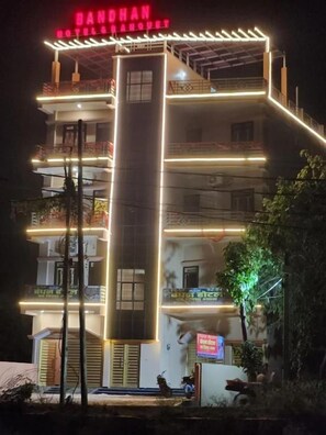 Un edificio de varios pisos con un letrero llamativo en la parte superior.