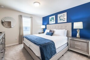A bedroom with a bed, bedside tables, a dresser, a mirror, and artwork on the wall. - Special Offer- 1min walk to Clubhouse, with SPA, Luxury 7BD Home 8900 (Kissimmee)