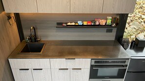 Eine moderne Küche mit eingebautem Geschirrspüler, Spüle und einer Arbeitsplatte mit verschiedenen Gegenständen.