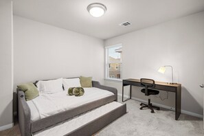 A bedroom with a bed, a desk, and a chair. - Comfort Meets Space - Feel Right at Home (Cypress)