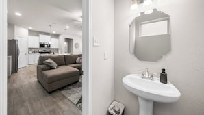 A modern kitchen with white cabinets, a microwave, and a refrigerator. - Comfort Meets Space - Feel Right at Home (Cypress)