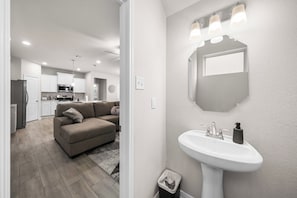 Une cuisine moderne avec des meubles blancs, un four à micro-ondes et un réfrigérateur.