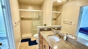 Ein Badezimmer mit Dusche, Toilette, Waschbecken und einem großen Spiegel.