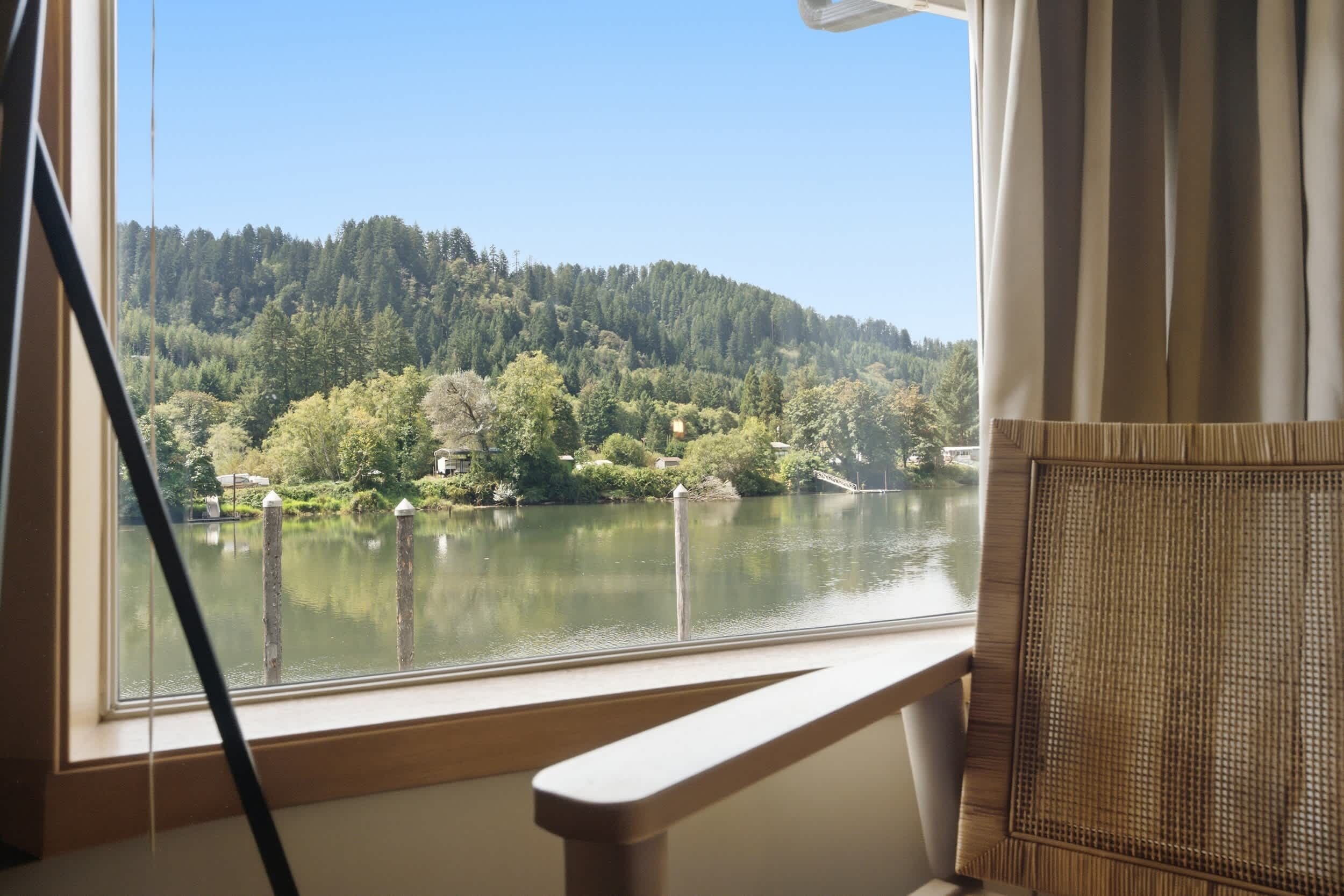 Una habitación con vista a un lago y un bosque.