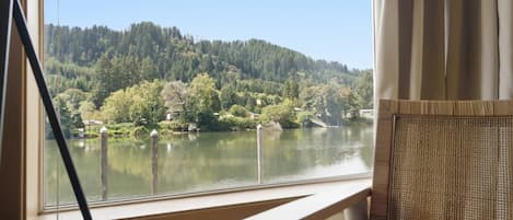 Una habitación con vista a un lago y un bosque.
