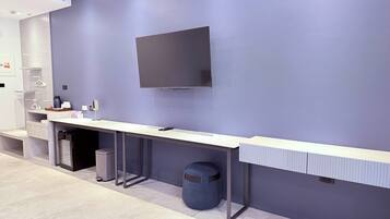 Ein moderner Empfangstresen mit Fernseher, Mülleimer und Papierkorb.
