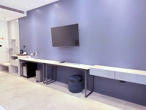 A modern reception desk with a flat-screen TV, a trash bin, and a waste basket. - Xingwan (Kaohsiung)