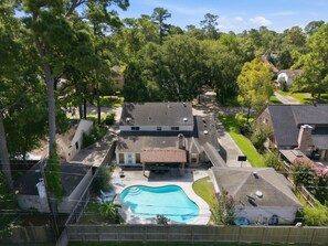 Ein Wohngebiet mit Schwimmbad, überdachter Terrasse und einem Haus mit Schrägdach.