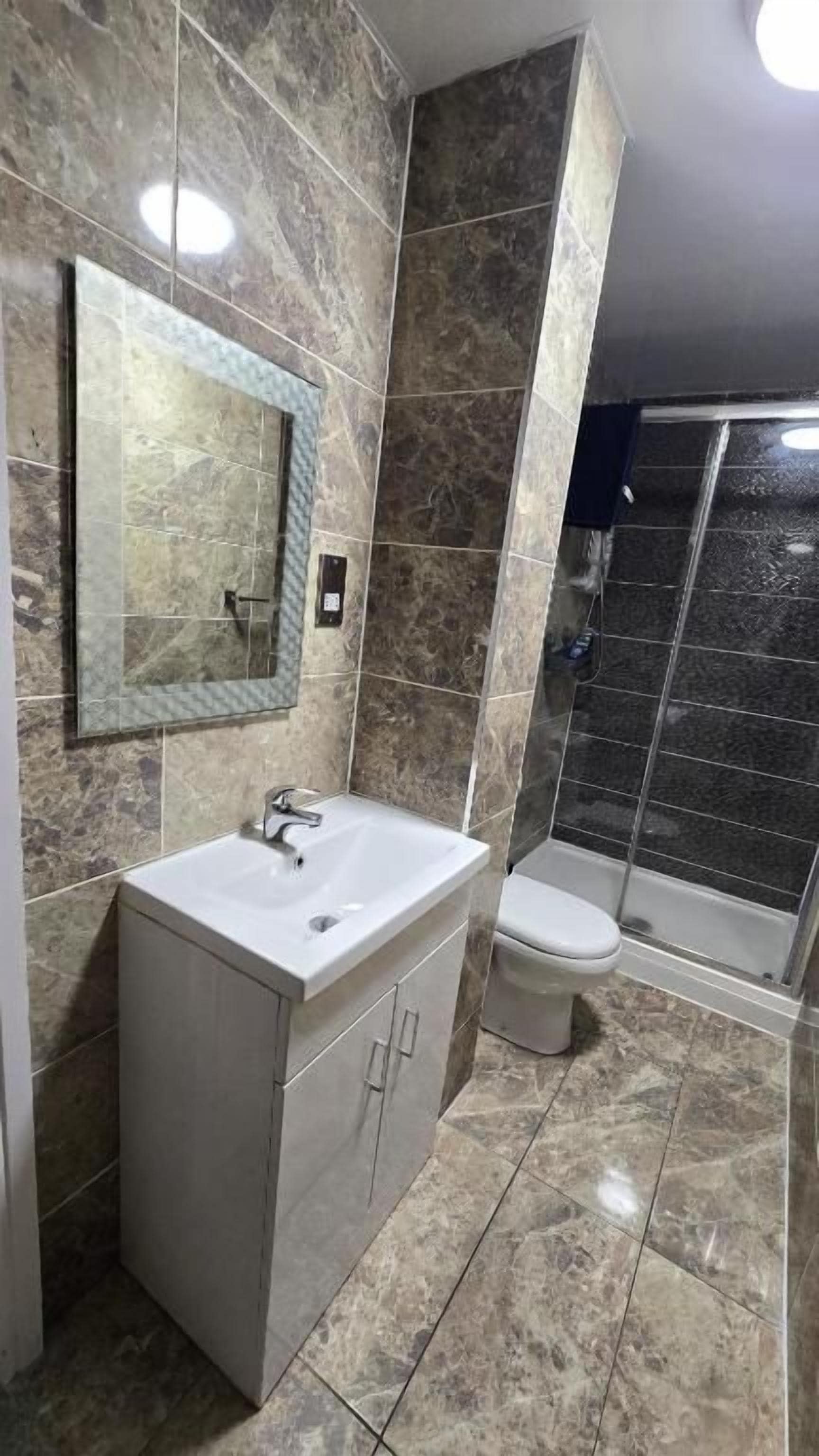 A bathroom with a sink, toilet, and shower area.
