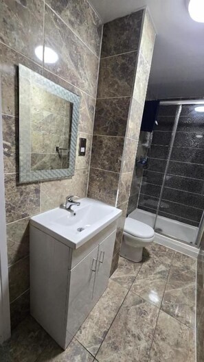 Ein Badezimmer mit Waschbecken, Toilette und Duschbereich.