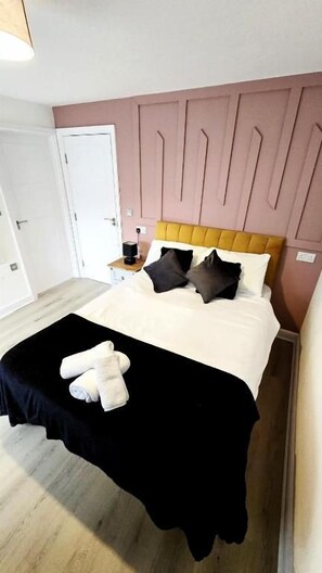 Ein Schlafzimmer mit einem Bett, einem Nachttisch und einer Tür.