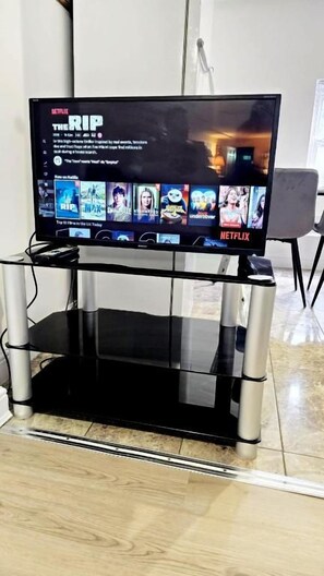 A television on a stand with a Netflix interface displaying the movie 'The Rip.' - City centre 2 Bed & 2 Bath Apartment. (Leicester)