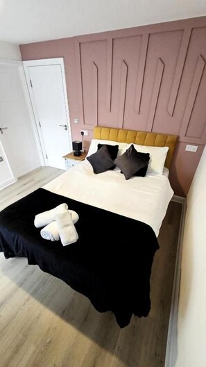 A bedroom with a bed, pillows, a nightstand, and a bedside table. - City centre 2 Bed & 2 Bath Apartment. (Leicester)