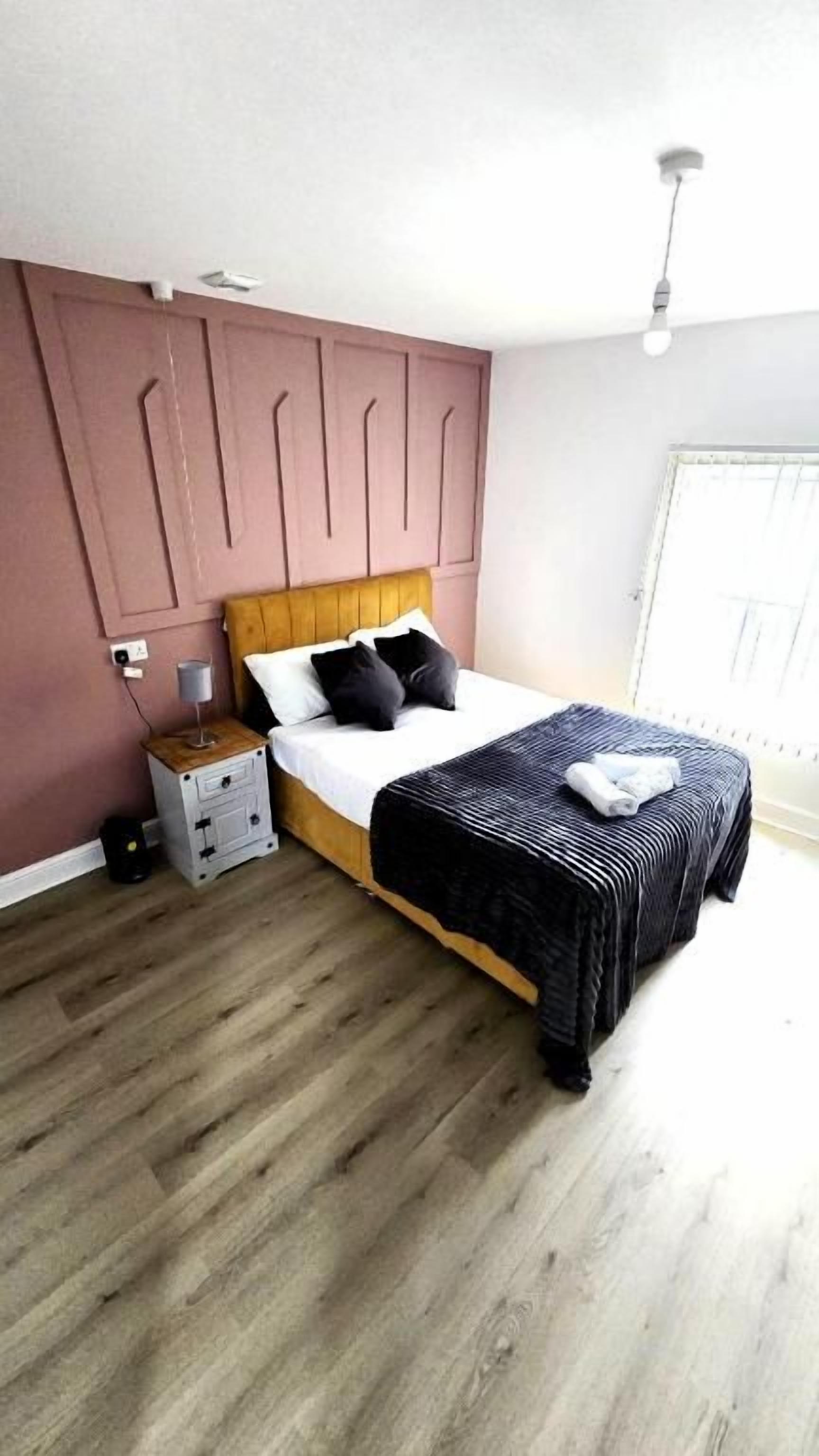 A bedroom with a bed, bedside table, and a wardrobe.