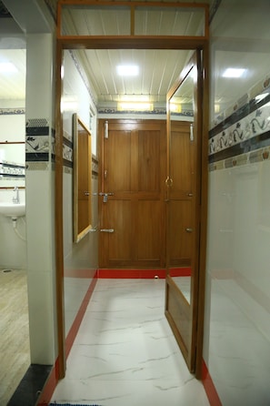Un baño con puerta de madera, un lavamanos y baldosas estampadas.