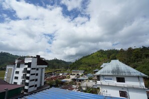 A building with a sign 'CASA MONTANA' and a view of a hilly landscape with tea plantations. - MSP Amma Cottage (Munnar)