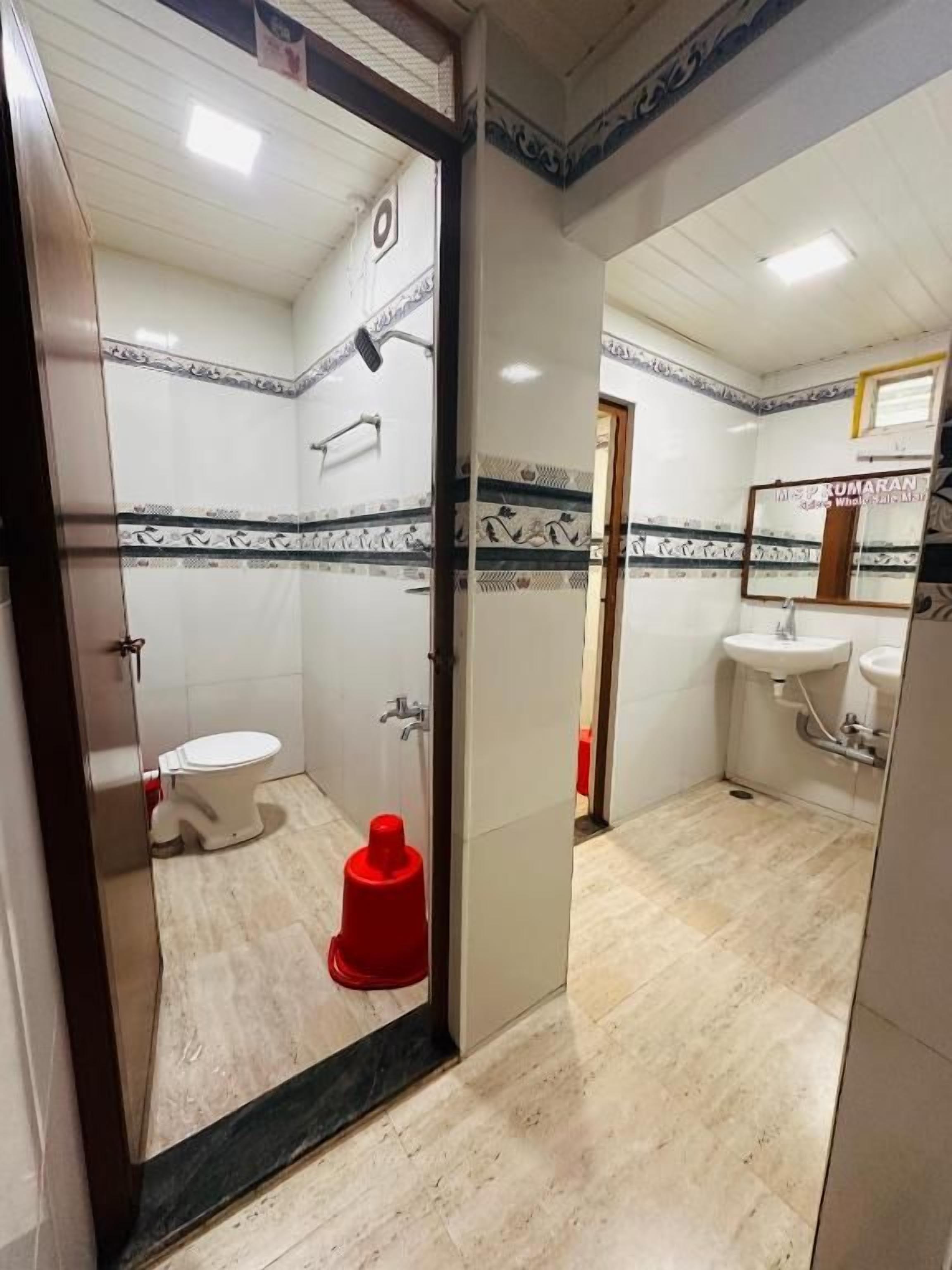 A bathroom with a toilet, sink, and shower area.