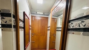 A hallway with a wooden door at the end, tiled walls with a decorative pattern, and a red line on the floor.