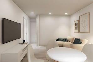 Ein modernes Wohnzimmer mit Flachbildfernseher, einer Couch, einem Couchtisch und Kunstwerken an den Wänden.