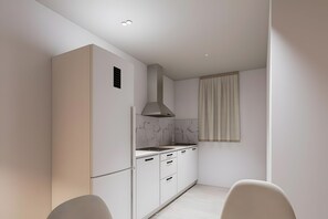 A modern kitchen with white cabinetry, a built-in stove, and a window with curtains. - Apartment 'Piso Martita' with Wi-Fi (Cedeira)