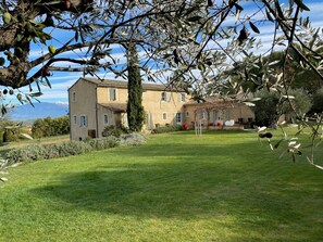 A two-story building with a garden in front.