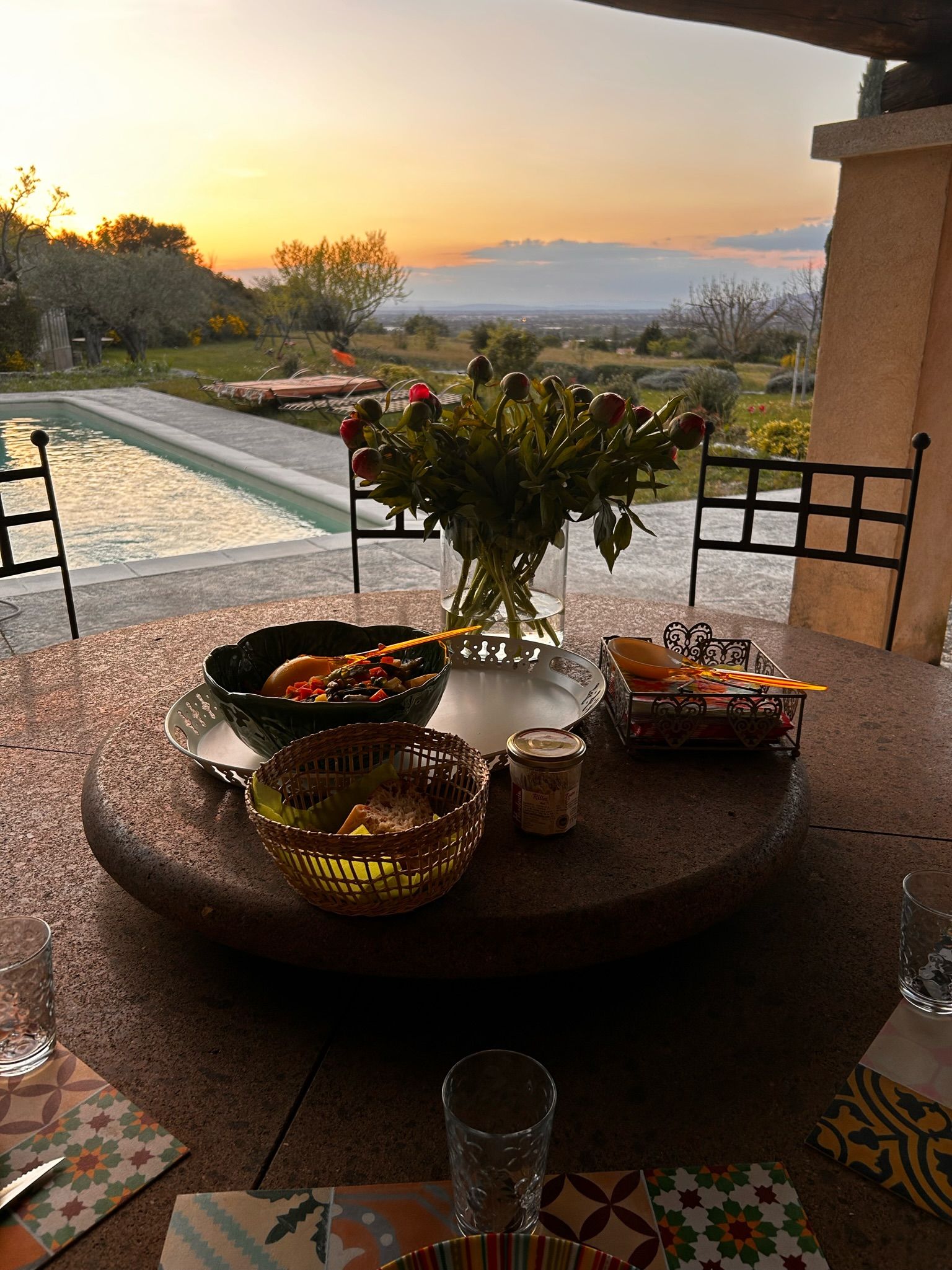 Mesa de comedor con vistas a una piscina y al paisaje, rodeada de sillas.