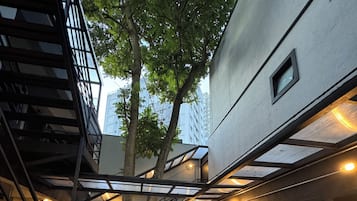 Une cour intérieure avec un escalier, un arbre et un bâtiment au design moderne.